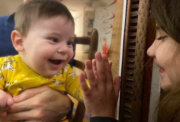 8-month-old Simon and 7-year-old Darwin interacting through a plastic barrier